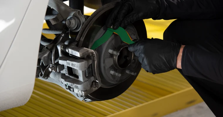 Technician checking brake pads on a car