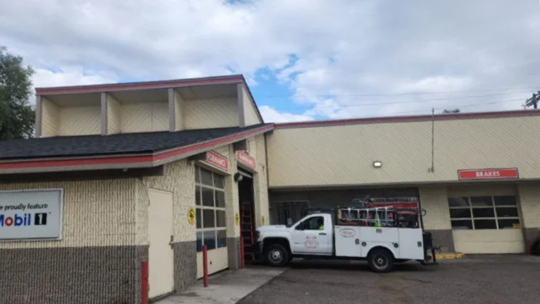 Exterior of Grease Monkey oil change center before renovation, showing older signage and faded building colors.