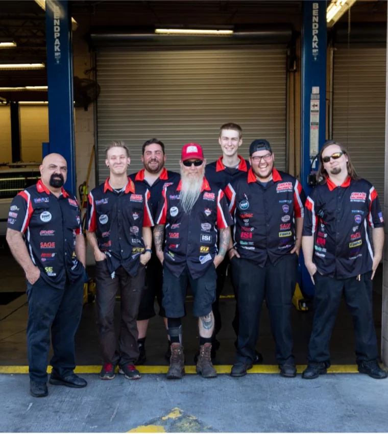 Grease Monkey service team standing together outside the shop, representing the welcoming and skilled crew.