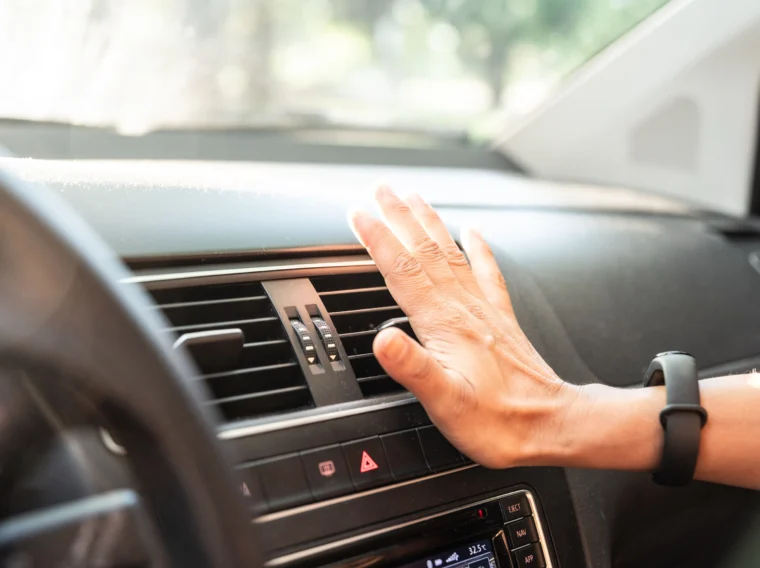 Closeup of hand checking the air conditioner in the car.