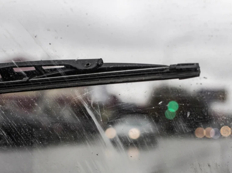 A close up of a windshield wiper on a car's windshield.